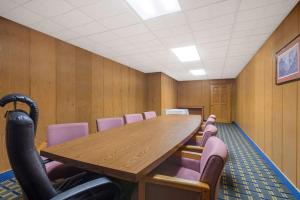 a conference room with a wooden table and purple chairs at Days Inn by Wyndham Roanoke Near I-81 in Roanoke