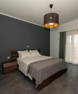 Ioulia`s Apartments في بلاتاريا: غرفة نوم بسرير كبير وثريا