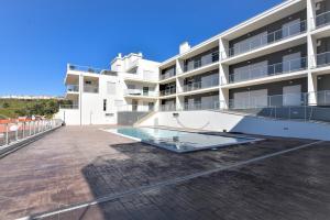 un edificio de apartamentos con piscina en el balcón en Apartamento T2 Kress Property, en Pederneira