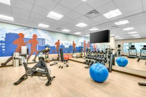 einen Fitnessraum mit Trainingsgeräten und Wandmalereien in der Unterkunft Hyatt Place Colorado Springs Downtown in Colorado Springs