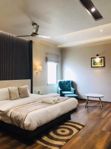a bedroom with a large bed and a blue chair at Royal Livin in Varanasi