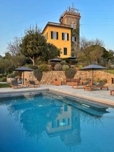 a pool with chairs and umbrellas in front of a building at Torre Scribanti in Sestri Levante +130 photos