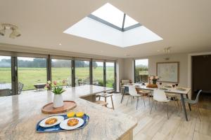 a kitchen and dining room with a large skylight at White Cottage, Iken - Aldeburgh Coastal Cottages in Snape