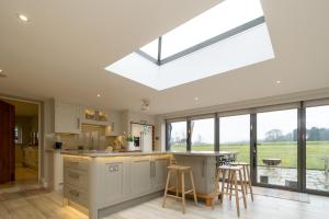 a kitchen with a large skylight in the ceiling at White Cottage, Iken - Aldeburgh Coastal Cottages in Snape +30 photos