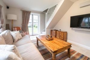 a living room with a couch and a table at White Cottage, Iken - Aldeburgh Coastal Cottages in Snape