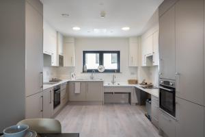 una gran cocina blanca con armarios y electrodomésticos blancos en Yugo Explore - Melbourn Point en Cork