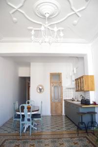 a kitchen with a dining table and a chandelier at Piso modernista en casco histórico con garaje in Cartagena