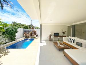 una sala de estar de planta abierta con piscina en una casa en Blanc Residence, en Pipa