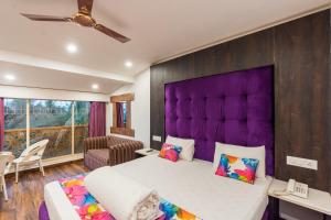 a bedroom with a large bed and a purple headboard at Lemonmint Svelton Manor in Calangute
