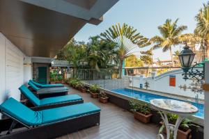 a balcony with blue lounge chairs and a swimming pool at Lemonmint Svelton Manor in Calangute