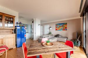uma sala de estar com uma mesa de madeira e cadeiras vermelhas em Oltre House em Lerici