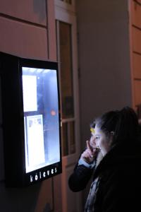 una mujer hablando en un celular delante de un televisor en Kőleves Fogadó, en Budapest