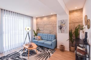 uma sala de estar com um sofá azul e uma mesa em Oporto lovely house deluxe no Porto