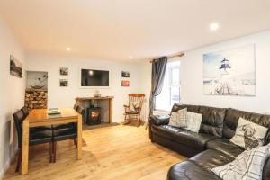a living room with a leather couch and a table at 29 Seafield Street in Whitehills