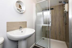 a white bathroom with a sink and a shower at 29 Seafield Street in Whitehills