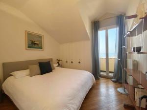 - une chambre avec un lit blanc et une grande fenêtre dans l'établissement CasaViva - Central Seaview Penthouse in Camogli, à Camogli