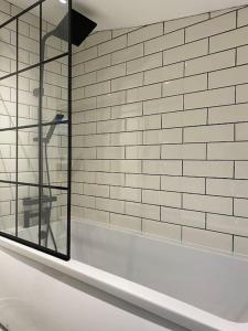 La salle de bains est pourvue d'une fenêtre et d'un mur en briques blanches. dans l'établissement Modern 2 bedroom cottage near Bike Park Wales., à Merthyr Tydfil