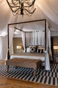 a bedroom with a canopy bed with a rug at The Alampara Resort in Cheyūr