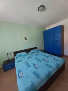 - une chambre avec un lit bleu et des armoires bleues dans l'établissement APARTMANI LANA, à Rab
