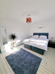 una camera con letto e tappeto blu di Visit Seaford Apartment - 4 Bedrooms a Seaford