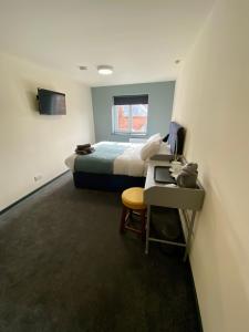 a bedroom with a bed and a desk with a computer at The Bridge Inn in Tenbury