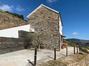 una casa de piedra al lado de una colina en Casa da Oliveira, en Mesão Frio