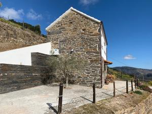 una casa in pietra sul fianco di una collina di Casa da Oliveira a Mesão Frio