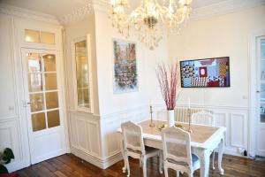 uma sala de jantar com uma mesa e cadeiras e um lustre em Van Gogh's Apartment - Montmartre em Paris