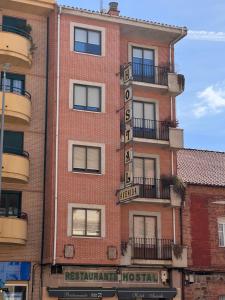 a brick building with a sign on the side of it at Hostal Avenida in Benavente
