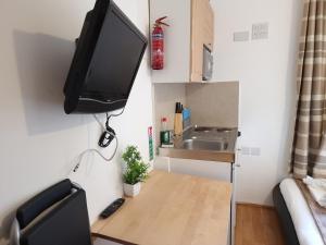 um pequeno quarto com uma televisão na parede em F204-Compact 2nd Flr Studio Fits 2-Near Hyde Park em Londres
