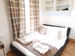 um pequeno quarto com uma cama e uma janela em F204-Compact 2nd Flr Studio Fits 2-Near Hyde Park em Londres