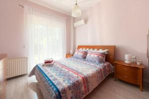 a bedroom with a bed and a large window at Greek Style Ground Floor Apartment & Pool in Triánta