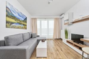 a living room with a couch and a tv at Apartment Krakowska 39 with AC & PARKING & LOGGIA Wrocław by Renters in Wrocław