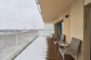 a balcony with chairs and tables on a building at Apartment Krakowska 39 with AC & PARKING & LOGGIA Wrocław by Renters in Wrocław