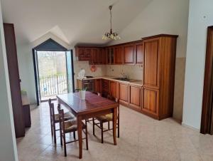 a kitchen with wooden cabinets and a table and chairs at Affittacamere Montepiano in Roccamontepiano