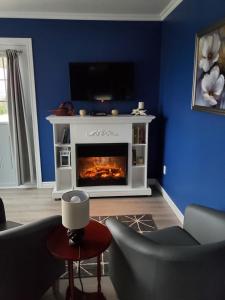 a living room with a fireplace with a tv on top at Dans Les Bras de Memphré in Magog-Orford
