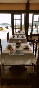 a dining room with three tables with chairs and a view at Pousada Gente Bonita Mirante in Búzios