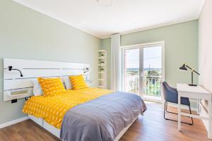 a bedroom with a bed and a desk and a window at Bela Vista - Beach Apartment in Praia de Mira