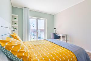 um quarto com uma cama com um edredão amarelo em Bela Vista - Beach Apartment na Praia de Mira