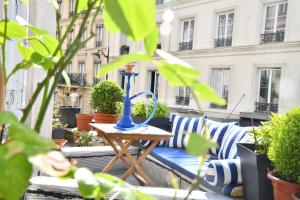 een patio met een blauwe tafel en een aantal planten bij Van Gogh's Apartment - Montmartre in Parijs