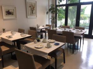 a restaurant with tables and chairs with cups and saucers at Rawson 3840 Alquiler de Suites La Lucila, Vicente Lopez, Buenos Aires in La Lucila