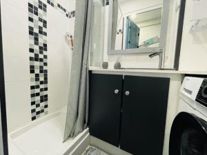 a bathroom with a sink and a washing machine at Appartement Royan, 200 m de la PLAGE in Royan +2 photos