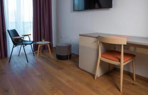 a room with a desk with two chairs and a table at Hotel Belmur in Murska Sobota