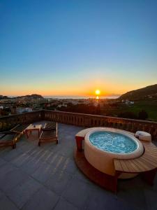 a hot tub on a roof with the sunset in the background at Torre Scribanti in Sestri Levante
