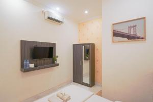 een kamer met een spiegel en een tv aan de muur bij Wisma D’King RedPartner in Pangkajene