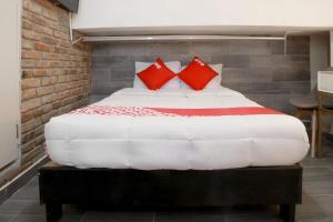 - une chambre avec un grand lit et des oreillers rouges dans l'établissement OYO Hotel Maria Otilia Falla, Papantla, à Papantla