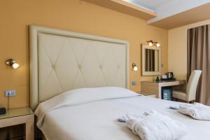 a bedroom with a white bed with towels on it at Grand Hotel Park in Dubrovnik
