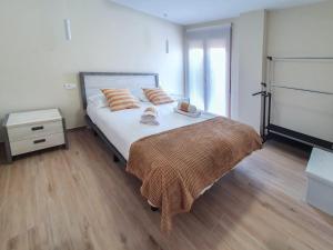 um quarto com uma cama grande e piso em madeira em DOMVS II em El Burgo de Osma