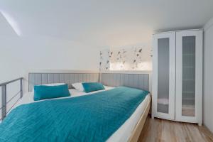 um quarto com uma cama grande e almofadas azuis em Urban Apartments Pula em Pula