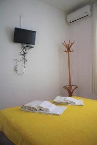 a room with a yellow table with a tv on the wall at Apartment Dora in Neum